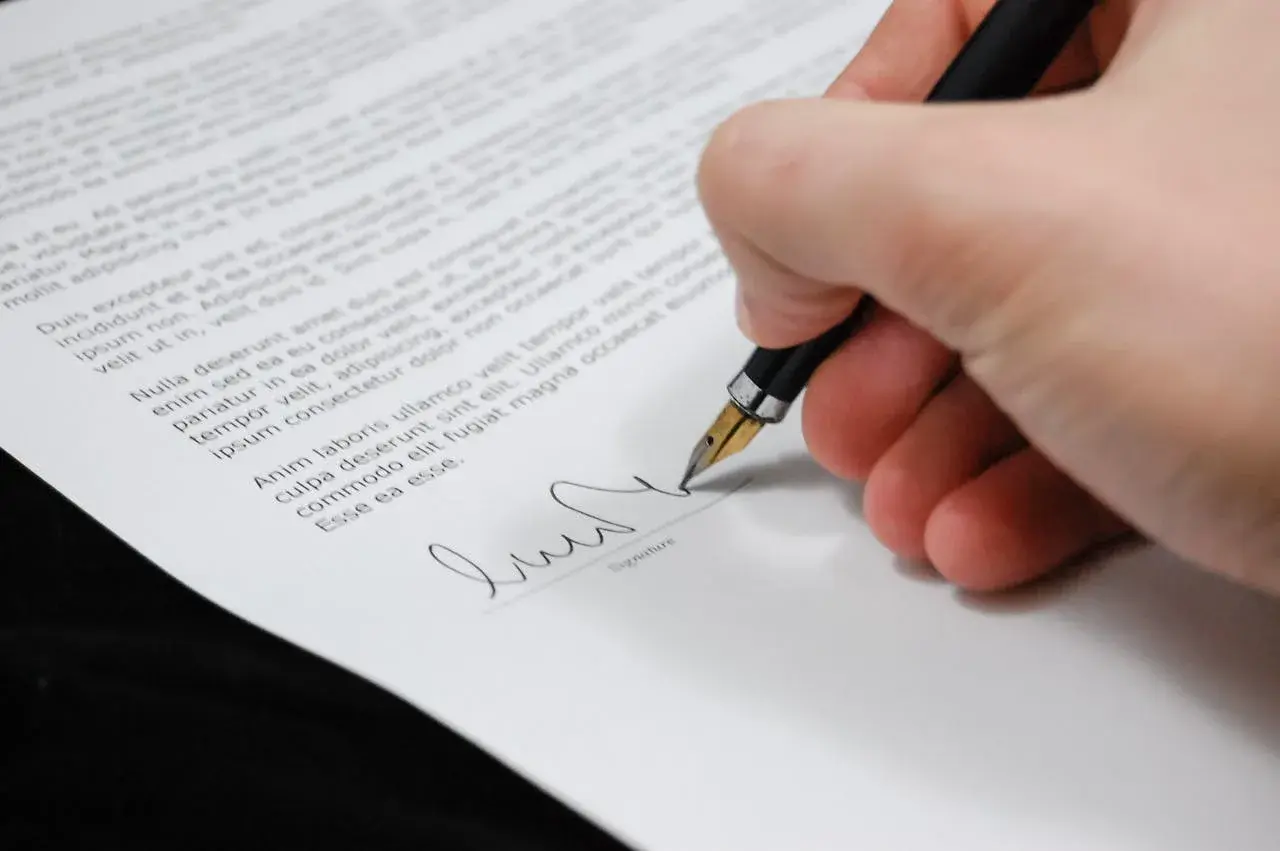hand with pen signing a contract